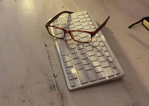 私の眼鏡をコンピューターのキーボードで見て — ストック写真