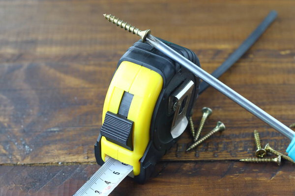 винты с отверткой Phillips и рулеткой
