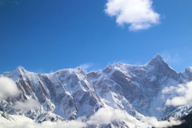Nanga Bawa Tepesi, karlı dağlar, mavi gökyüzü, beyaz bulutlar, halk evleri ve dağlarda vahşi şeftali çiçekleri.!