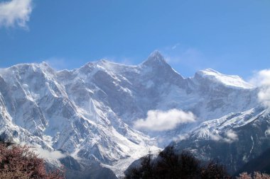 Dağların ve pembe şeftali çiçeklerinin arasından Nanjiabawa Tepesi 'ne bakarken, mavi gökyüzüne, beyaz bulutlara ve yeşil suya karşı, daha dik ve görkemli.!