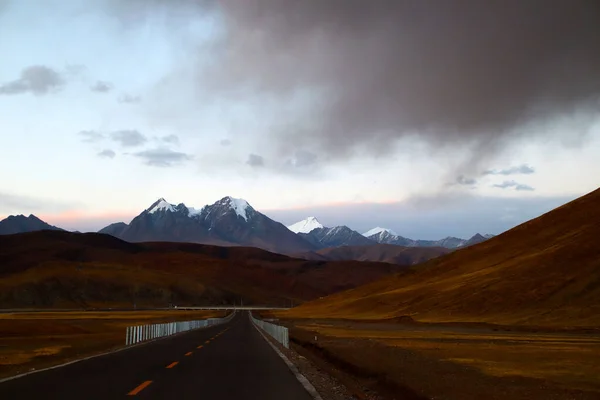 Bajo Atardecer Las Montañas Nevadas Distancia Las Laderas Marrones Montaña — Foto de Stock