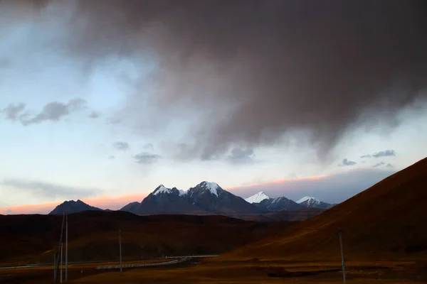 Bajo Atardecer Las Montañas Nevadas Distancia Las Laderas Marrones Montaña — Foto de Stock