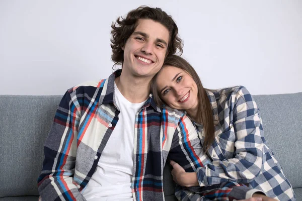 Щаслива молода пара на дивані дивиться на камеру у вітальні — стокове фото