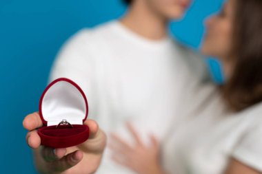 Mavi arkaplanda evlilik yüzüğü olan çiftlerin kısmi görünümü