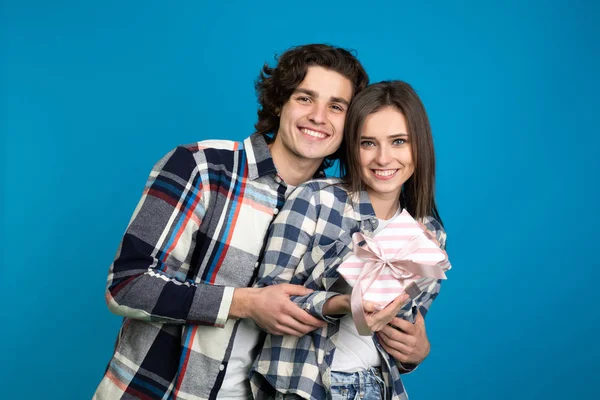 Вид спереду щасливої пари з подарунком ізольовано на синьому фоні — стокове фото