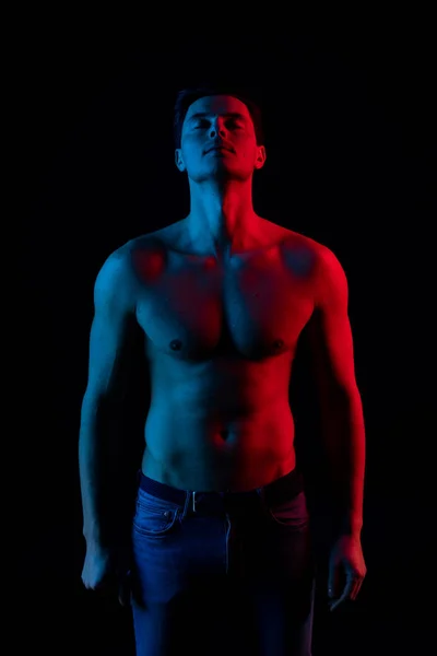 Hombre en estudio con colores rojo y azul. Mira la cámara y sonríe — Foto de Stock