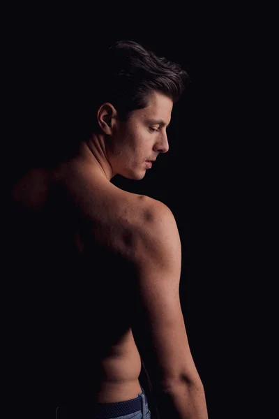 Barechested guy with a dramatic light in the Studio. looks aside, the silhouette of the man. close-up — Stok fotoğraf