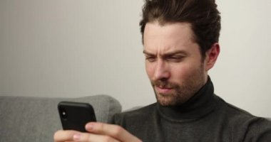 Genç erkekler evdeki akıllı telefonları kullanarak kanepede dinleniyorlar. Genç adam mesaj yazıyor, davaların listesi. Odaklanmış kişi kameraya bak. Kapalı