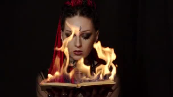 Přední pohled tetované ženy s copánky držící hořící knihu