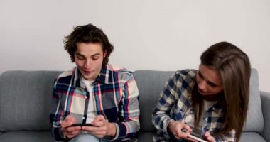 Mutlu çift akıllı telefon kullanıyor, beşlik çakıyor, sarılıyor ve gülümsüyor.