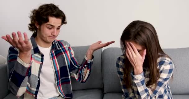 Irritated couple with crisis discussing problem on couch in living room — 비디오