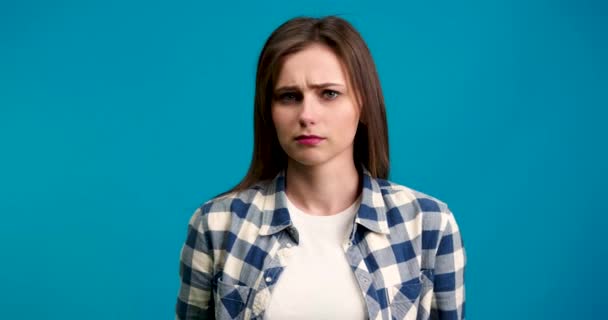 Vorderansicht einer unzufriedenen Frau, die den Kopf schüttelt und isoliert auf blauem Hintergrund in die Kamera schaut — Stockvideo