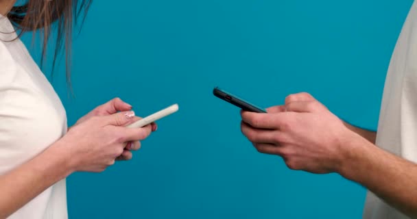 Partial view of couple using smartphones isolated on blue background — Stock Video