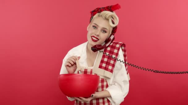 Pin up blonde woman cooking and talking on telephone with smile — Stock Video