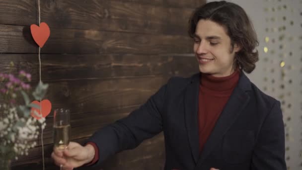 Sonriente hombre tintineo copas de champán y el intercambio de regalos de San Valentín — Vídeo de stock