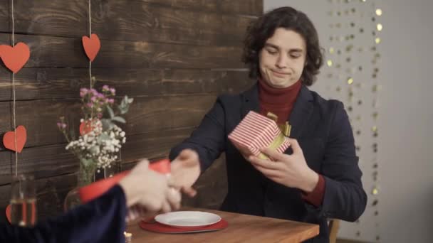 Hombre intercambiando regalos con novia y escribiendo en el teléfono inteligente — Vídeos de Stock