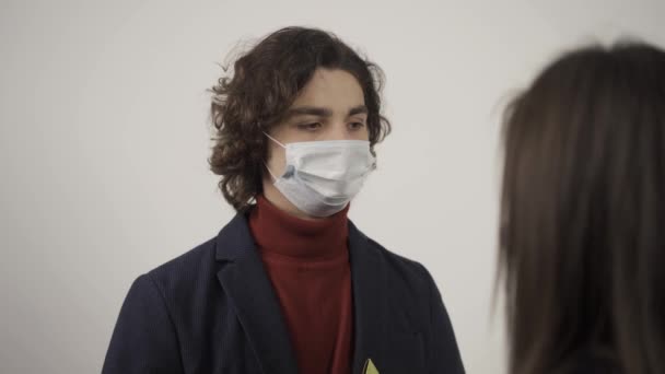 Beskuren syn på kvinnan talar med mannen i medicinsk mask — Stockvideo