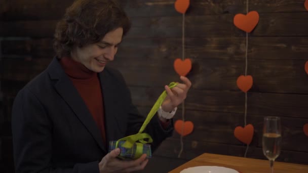 발렌타인데이에 선물을 여는 젊은 남자의 웃음 — 비디오
