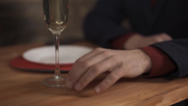 Vista recortada del hombre con copa de champán tocando en la mesa — Vídeos de Stock