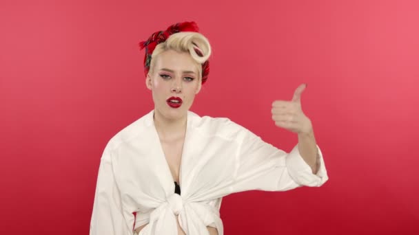 Sceptische pin up meisje tonen duim naar beneden op roze achtergrond — Stockvideo