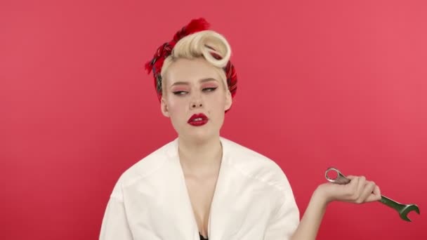 Fáradt pin up lány holding csavarkulcs és sóhajtozik rózsaszín háttér — Stock videók