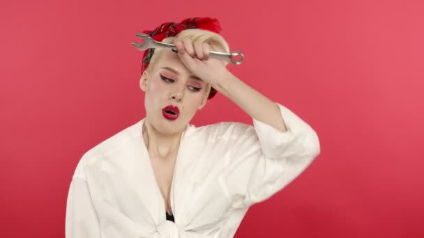Zmęczony pin się blondynka dziewczyna z kluczem wzdychając na różowym tle — Wideo stockowe