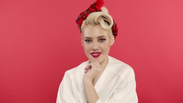 Flirty pin up woman with ribbon smiling on pink background — Stock Video