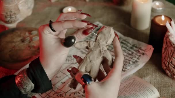 Gewassen uitzicht op heks met ringen steken naald in voodoo pop — Stockvideo