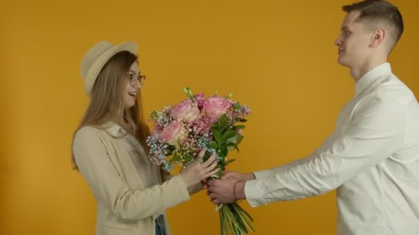 Jovem apresentando buquê de flores para namorada surpresa — Vídeo de Stock