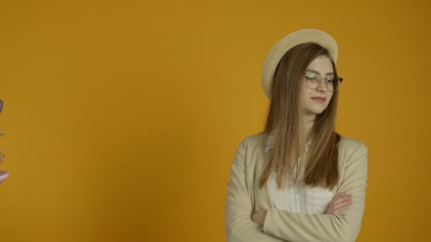 Девушка в очках отказывается от букета тюльпана на желтом фоне — стоковое видео