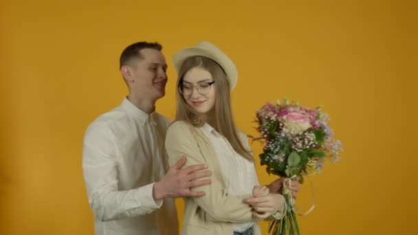 Man presenterar bukett, kysser och omfamnar flickvän — Stockvideo