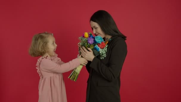 Schattig kind presenteren bloemen, omarmen en kussen moeder — Stockvideo