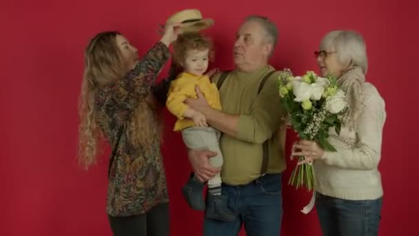 Familjen poserar med blommor och liten söt unge — Stockvideo