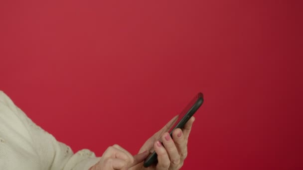 Обрезанный вид пожилой женщины прокрутки и печатания на смартфоне — стоковое видео