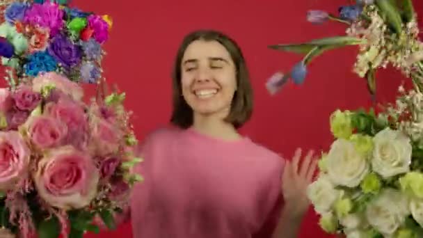 Emocionado chica de pelo corto sonriendo y bailando cerca de flores — Vídeos de Stock