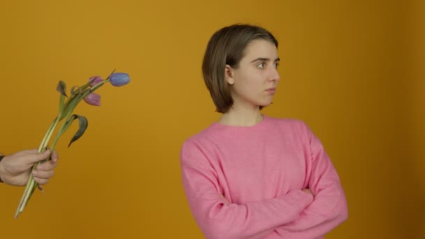 Beledigd meisje staat met gekruiste armen en negeert bloemen — Stockvideo