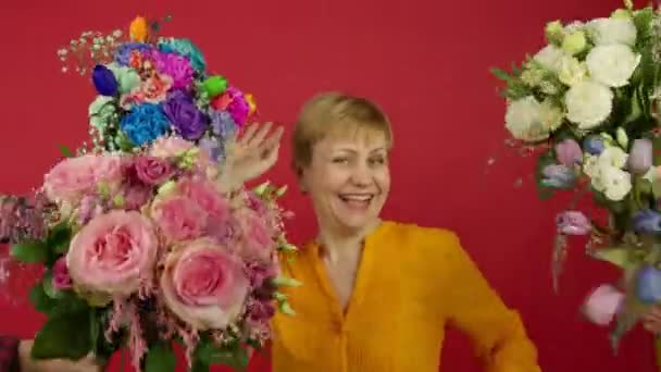 Opgewonden volwassen vrouw dansen in de buurt van bloemen met glimlach — Stockvideo