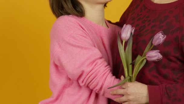 Mosolygó középkorú nő átöleli lánya virágokkal — Stock videók