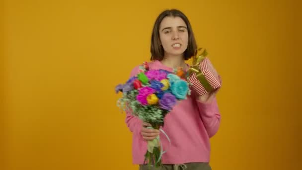 Chica feliz mostrando flores y caja de regalo con sonrisa — Vídeos de Stock