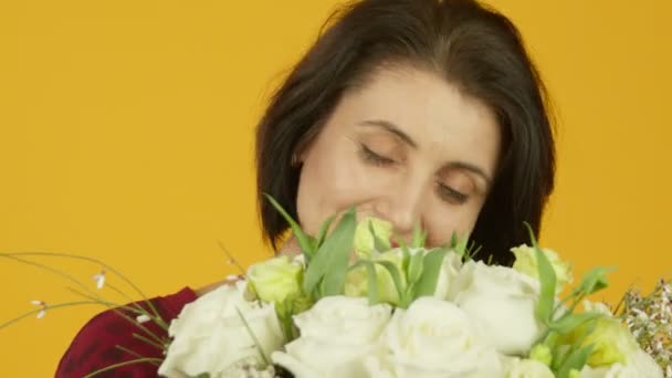 Szczęśliwa dojrzała kobieta wąchająca róże z uśmiechem — Wideo stockowe