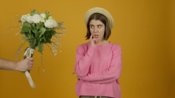 Ragazza pensierosa in cappello guardando bouquet con sorriso scioccato e fiutando fiori — Video Stock