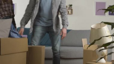 Taşındıktan sonra kanepede kucaklaşan gülümseyen çift.