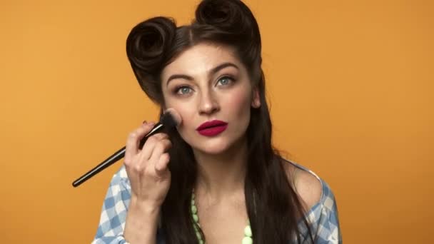 Pin up woman with brush applying powder on face with smile — Stock Video