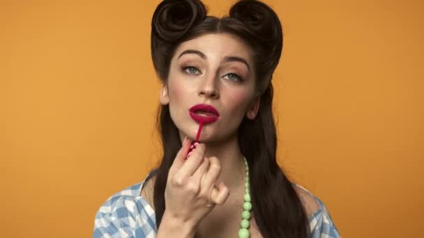 Attractive pin up girl applying lipstick and smiling at camera — Stock Video