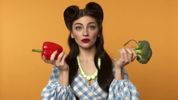 Teleurgesteld pin up vrouw op dieet houden paprika en broccoli — Stockvideo