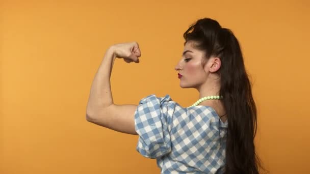 Fuerte pin up mujer mostrando bíceps y guiño a la cámara — Vídeo de stock