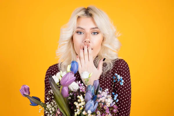Вид изумленной девушки с цветами, закрывающими рот рукой — стоковое фото