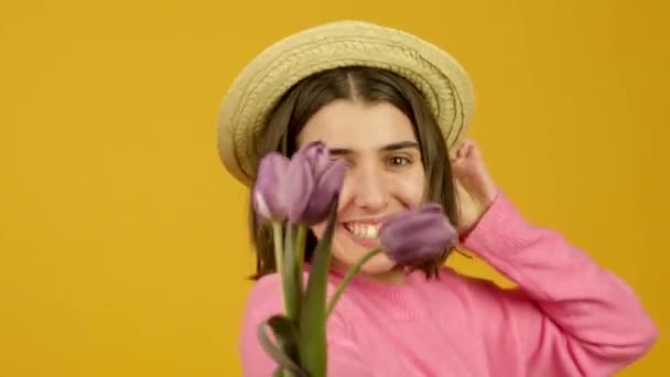 Menina elegante no chapéu sorrindo e cheirando tulipas com olhos fechados — Vídeo de Stock