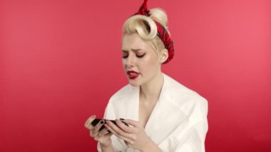 Gülümseyen kız akıllı telefondan yazı yazıyor ve evet işareti yapıyor.