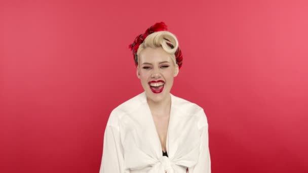 Blondýny pin up dívka se směje a třese hlavou na růžovém pozadí — Stock video